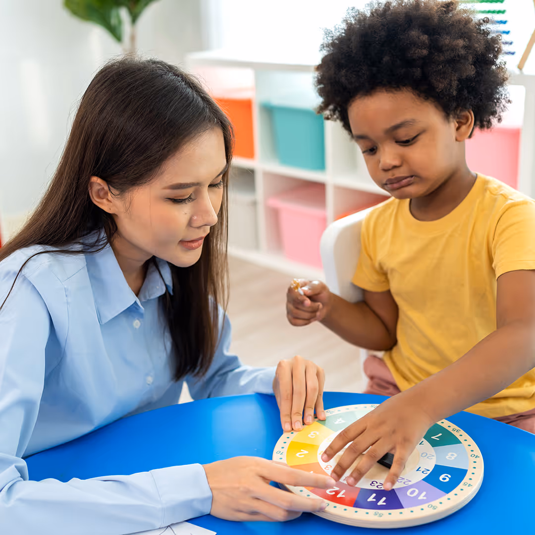 Adult asian female plays with young black child. Play Therapy at Therapy Academy in Frisco, TX