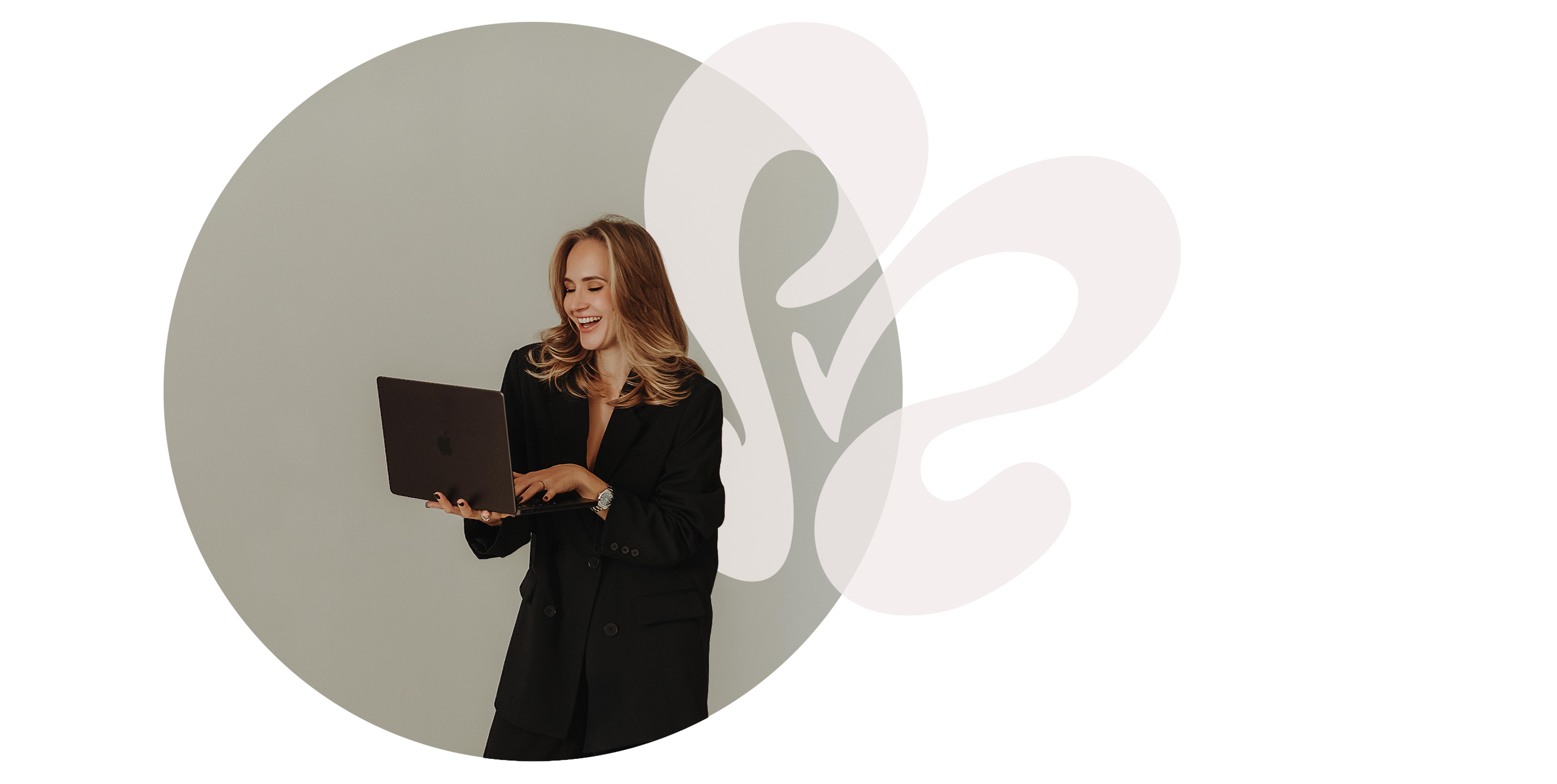 Smiling woman in black blazer holding and using a laptop, with abstract white shapes in background.
