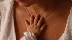 Hand eines Babys auf der Schulter einer Mutter