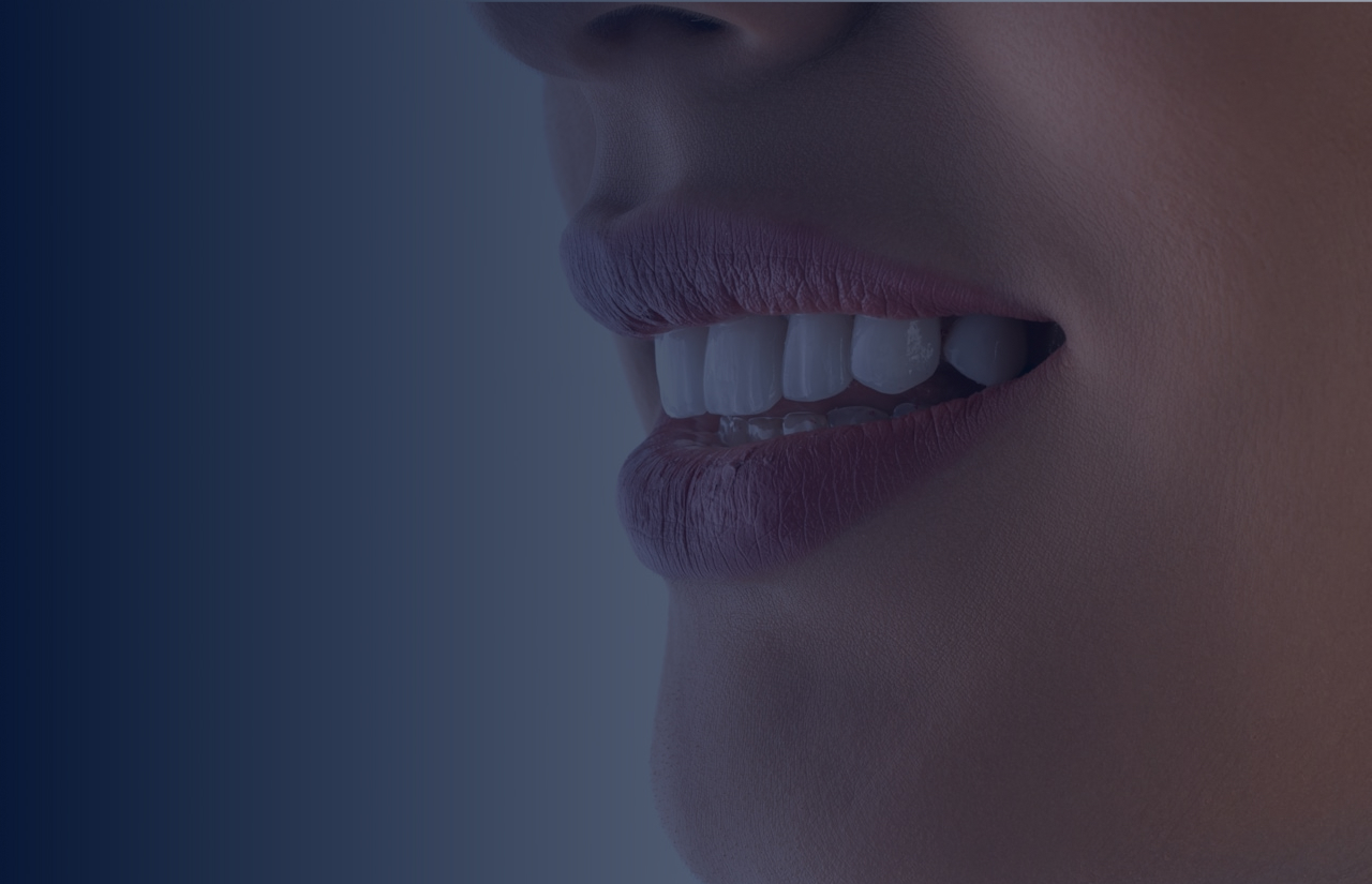 Closeup of lips and teeth against a dark blue gradient background