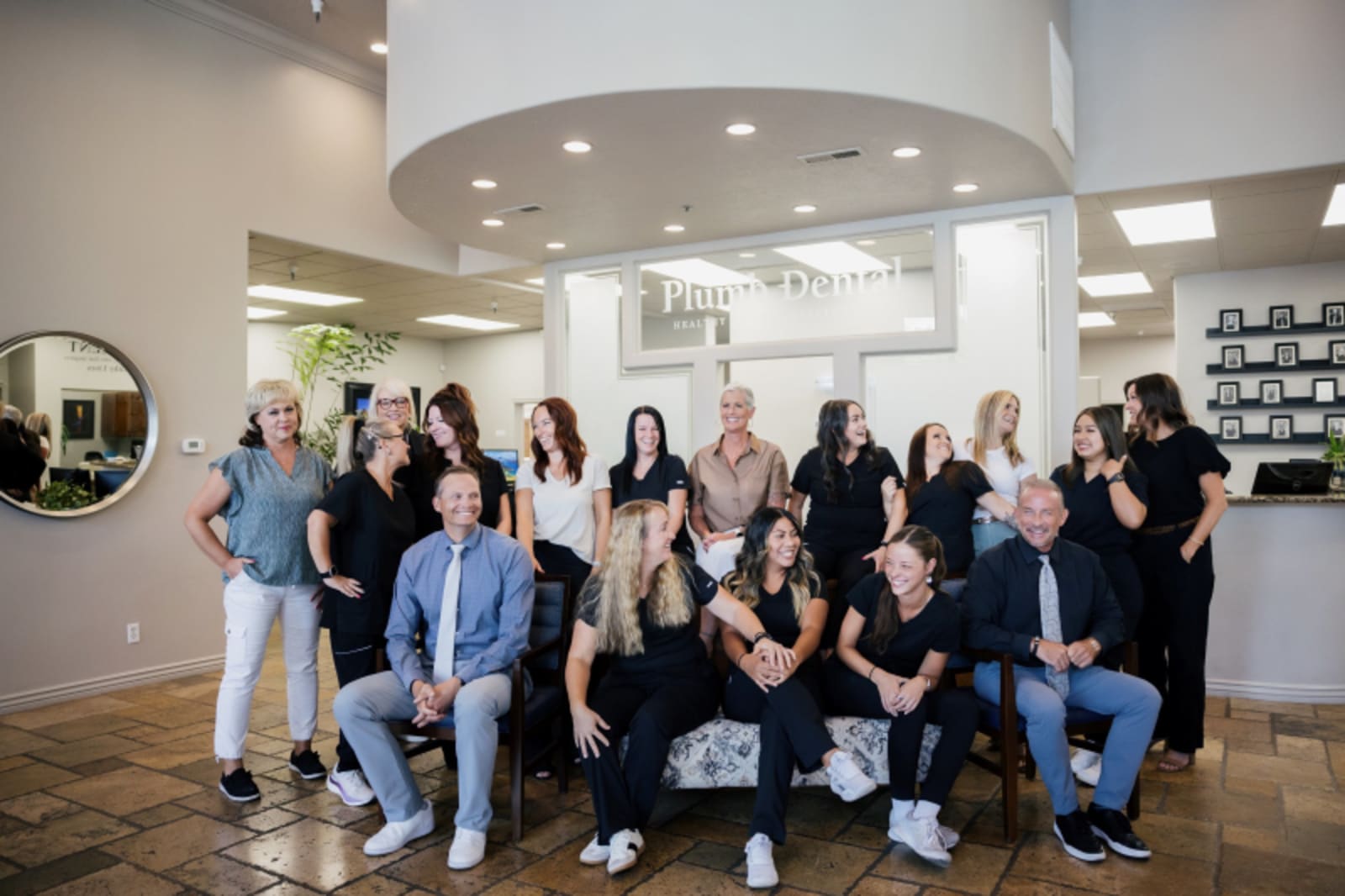 Plumb Dental team gathered in the modern reception and treatment area