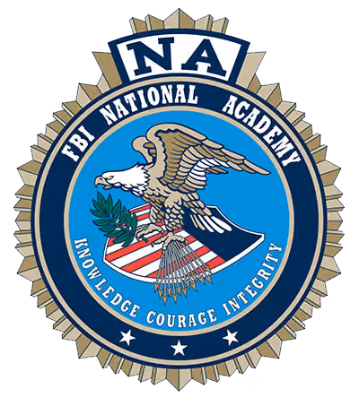 Badge of FBI National Academy with eagle holding olive branch and arrows, text: knowledge courage integrity.