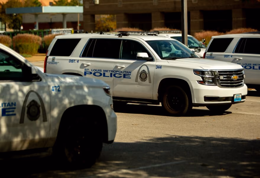White St. Louis Metropolitan Police SUVs parked outdoors in a lot with building in background.