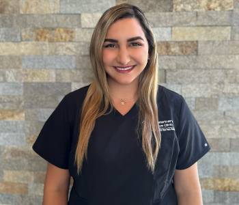 Professional picture of a woman wearing dark blue scrubs.