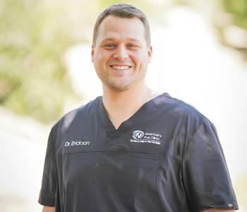 Professional picture of a man wearing grey scrubs.