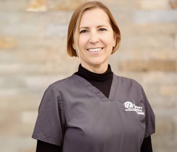 Professional picture of a woman wearing grey scrubs.