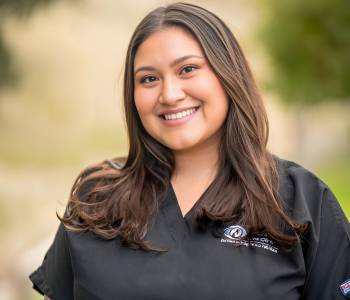 Professional picture of a woman wearing grey scrubs.