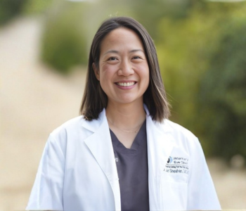 A professional picture of a woman wearing a doctor's lab coat. 