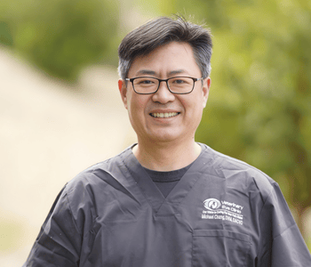 Professional picture of a man wearing grey scrubs.