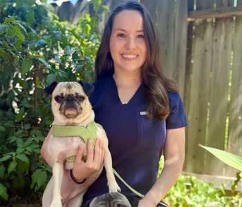Picture of Dr. Averi Kapian holding her pet pug.