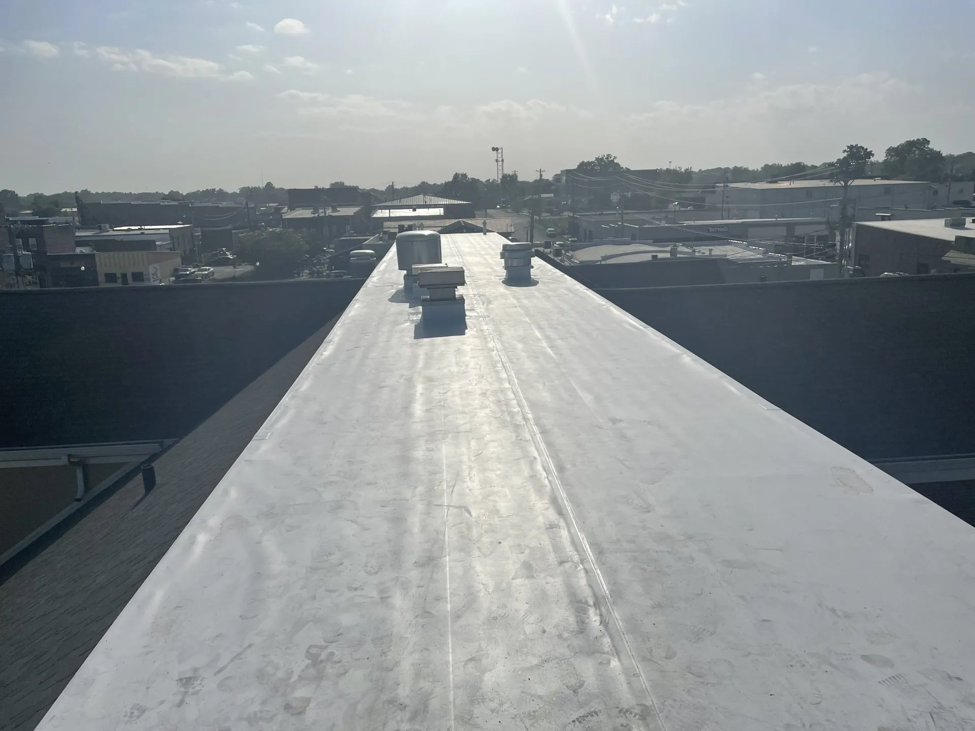 Flat commercial roof with new protective membrane installed by Allen’s Roofing