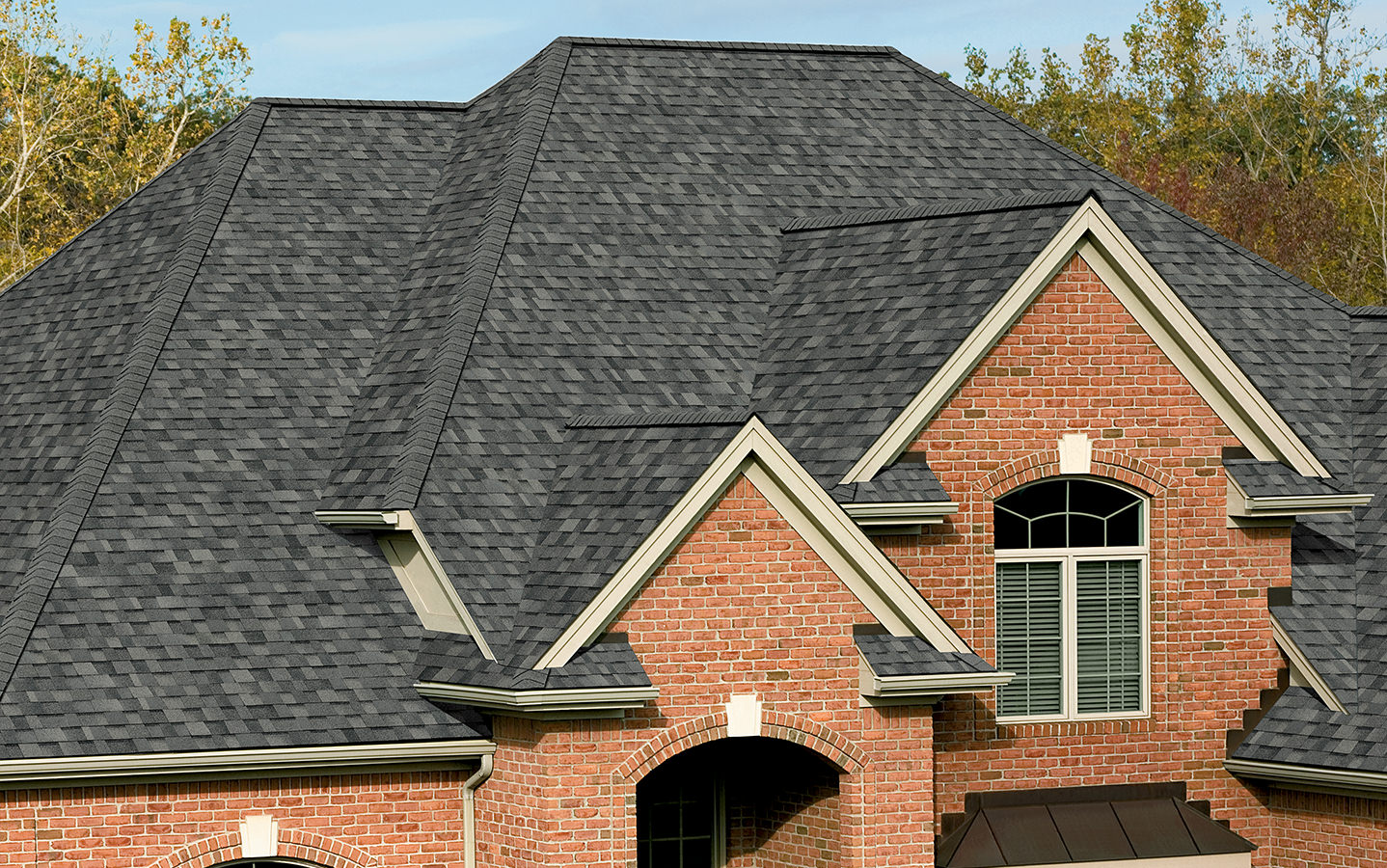 Suburban neighborhood with new residential roofs under clear sky