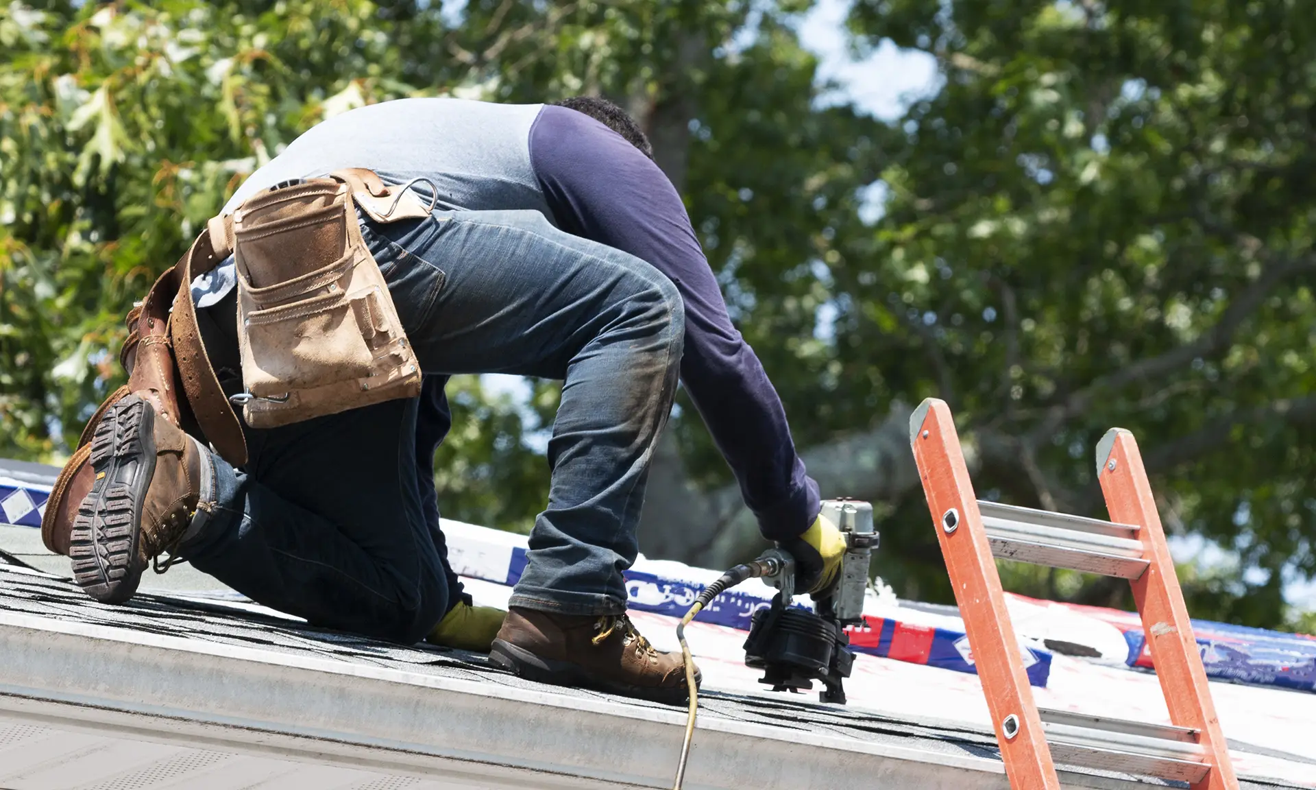 Worker applying waterproofing and insulation on flat roof