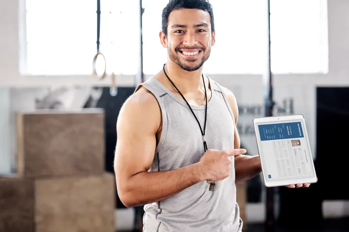A man holding a tablet with a smiling face.