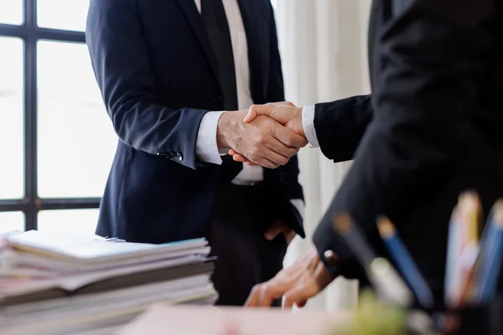 Two men shaking hands in a business meeting.