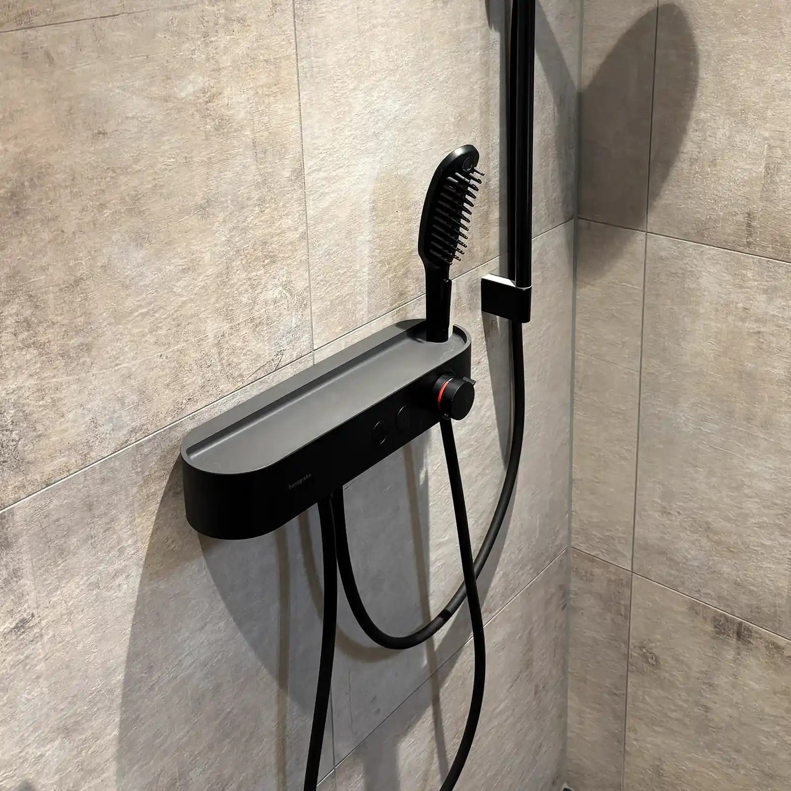 Moderne Dusche mit schwarzer Armatur und Steinoptik nach Badsanierung in Tirol