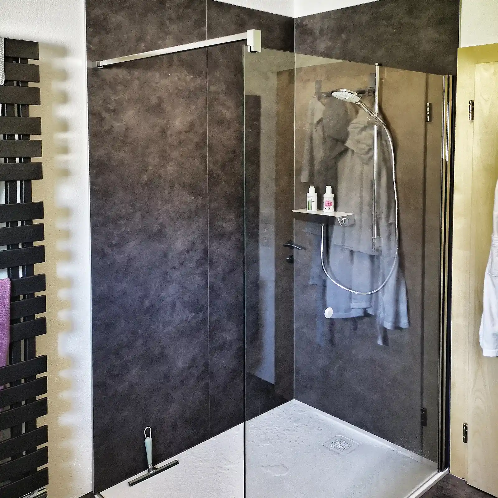 Moderne Walk-In-Dusche mit dunkler Steinoptik und klarer Linienführung nach der Badsanierung.
