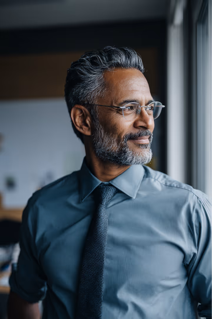 Man smiling looking out a window