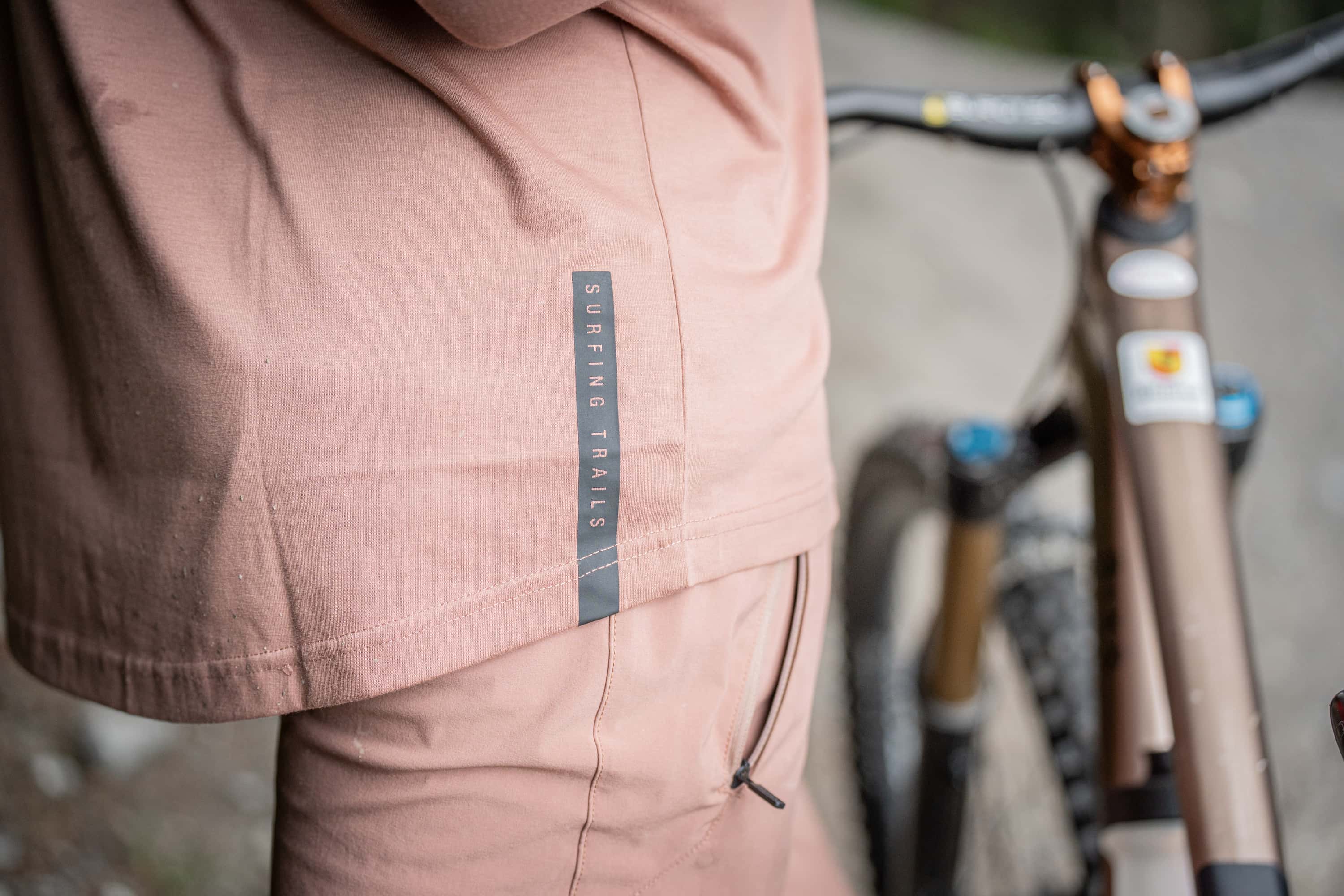 Das Bild zeigt einen Biker mit Fahrrad stehend in einem Pumptrack