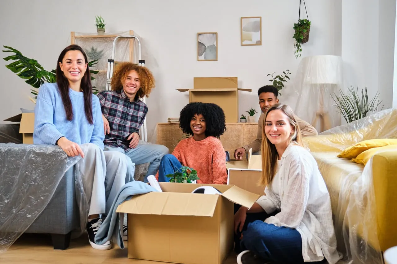 Professional movers carrying boxes and furniture during a residential move
