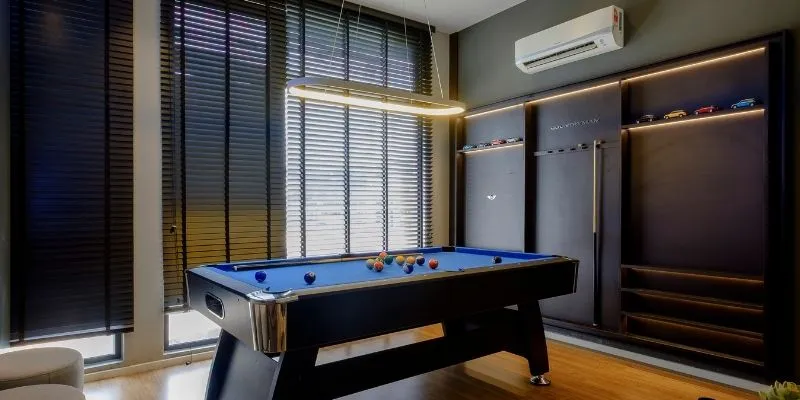 Movers disassembling and wrapping a pool table for moving