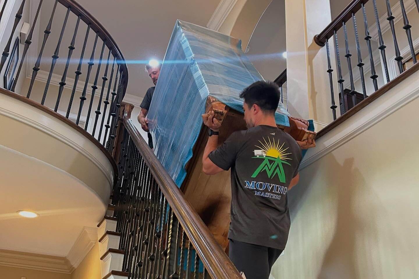 Movers carrying furniture and boxes during a local residential move