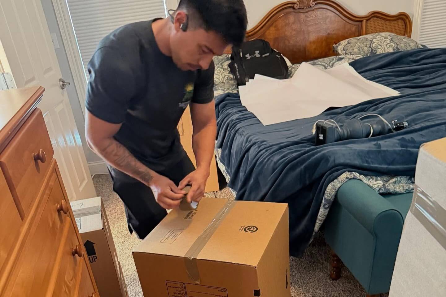 Household items being carefully packed into cardboard moving boxes
