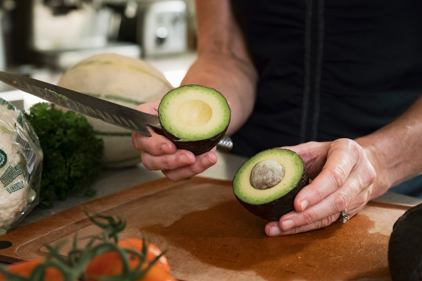 A avocado has been cut in half for a nutritious meanl.