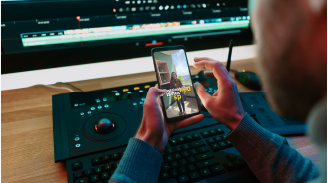 Busy office with multiple cubicles where employees work on computers, some wearing headsets and orange lanyards.