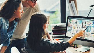 Busy office with multiple cubicles where employees work on computers, some wearing headsets and orange lanyards.