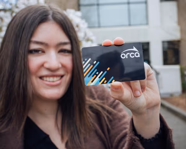 Rider holding an Orca Card