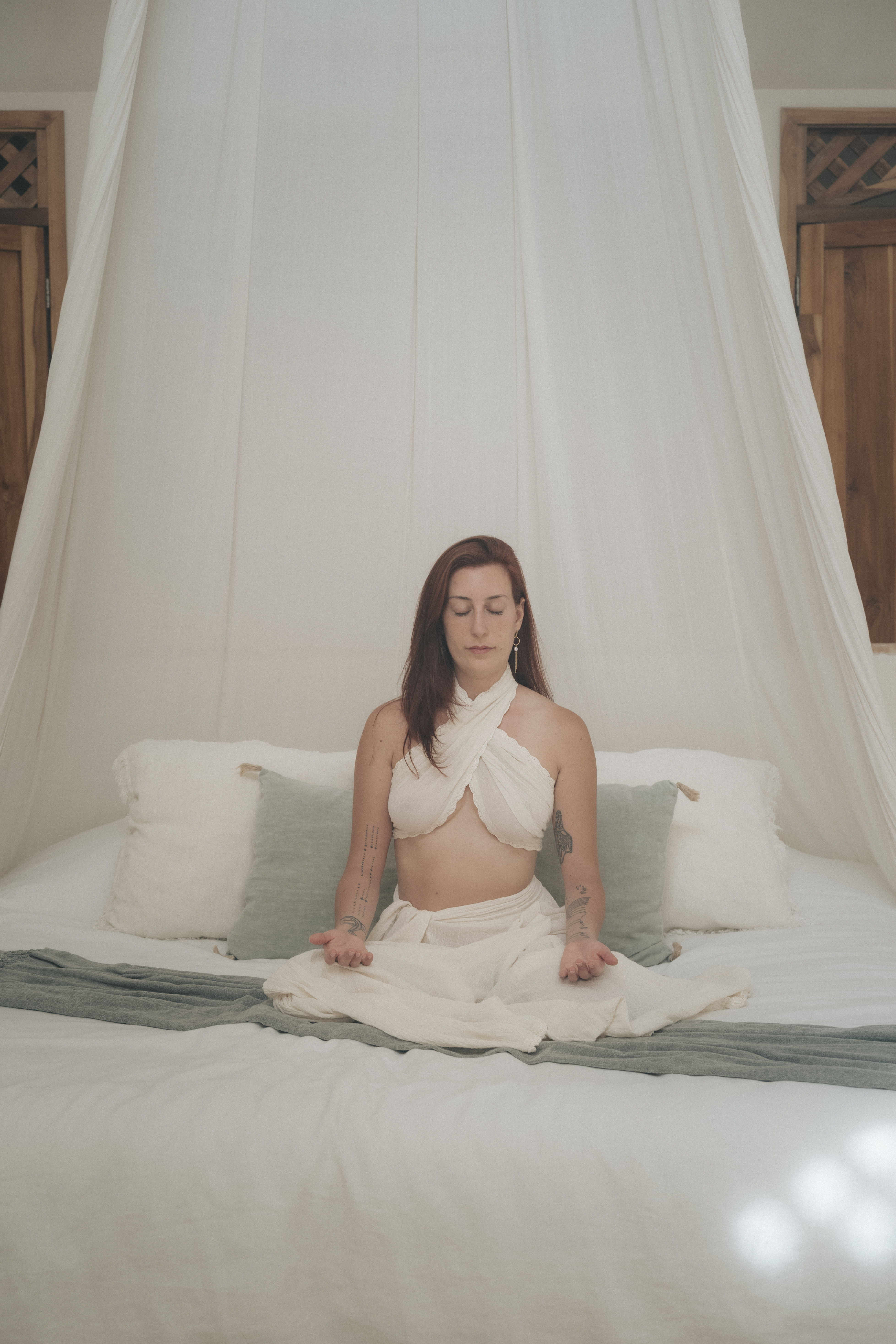 Delfina seated in meditation on a bed
