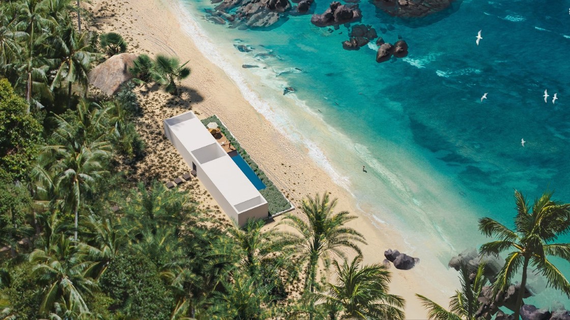 Aerial view of a tropical beach with private villas set among palm trees
