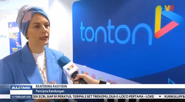 Woman in headscarf and blue blazer being interviewed with a Tonton logo backdrop.