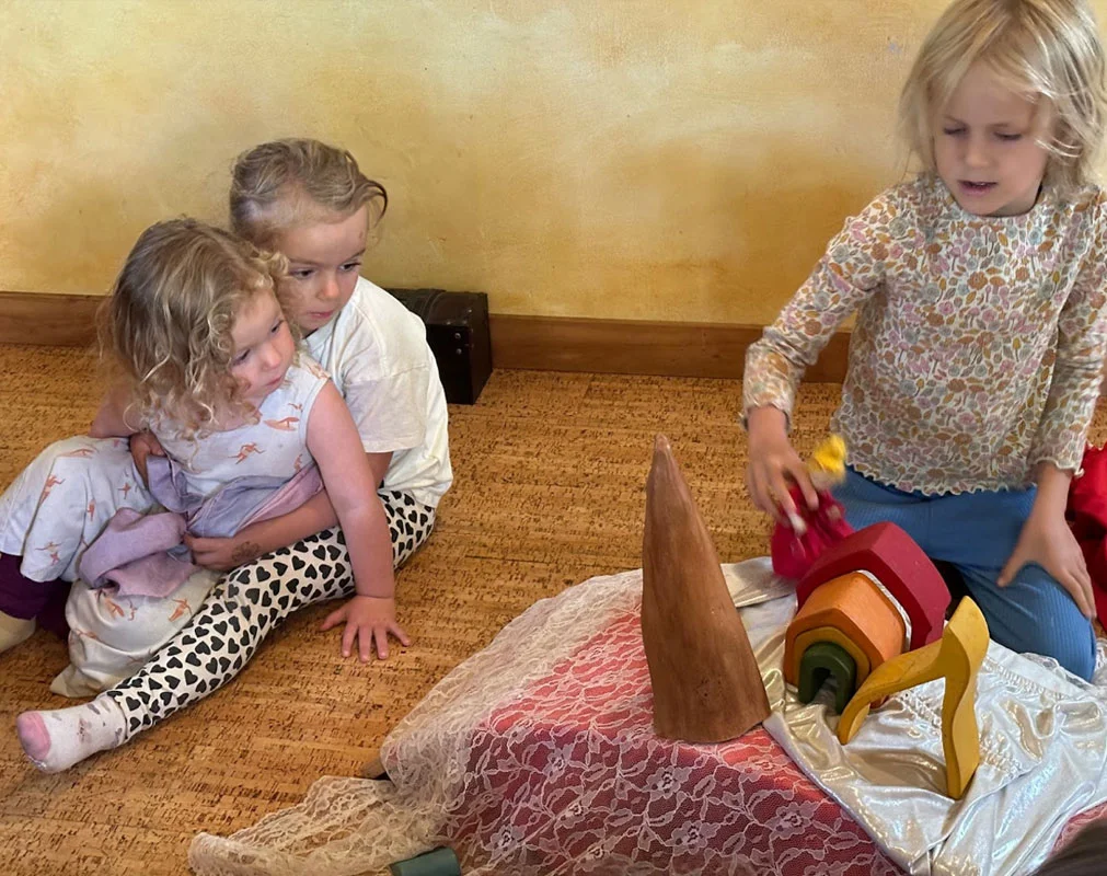 Children in colorful rain gear playing outside, experiencing joy and movement in all-weather nature play.