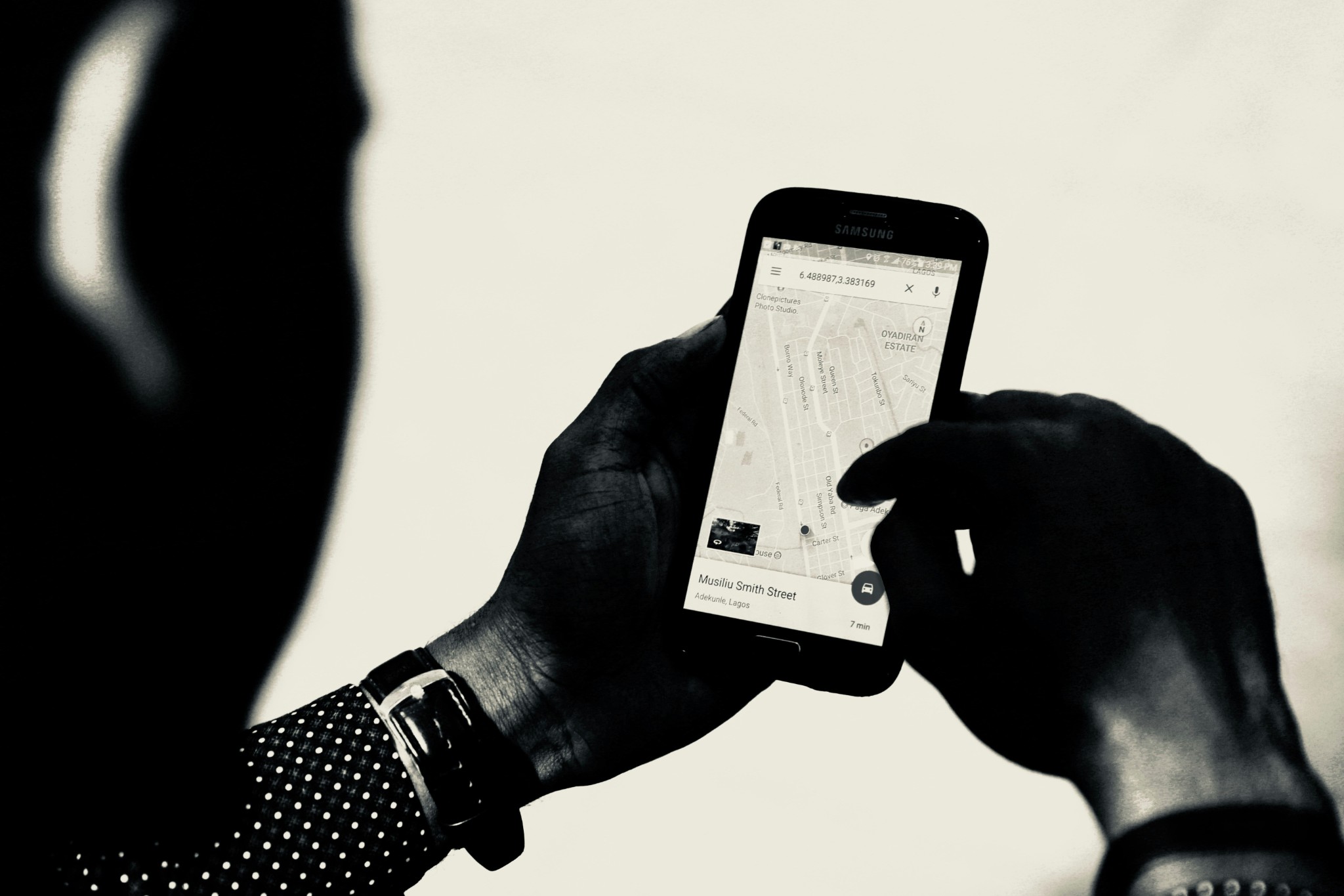 Person using smartphone map app to navigate city street location.