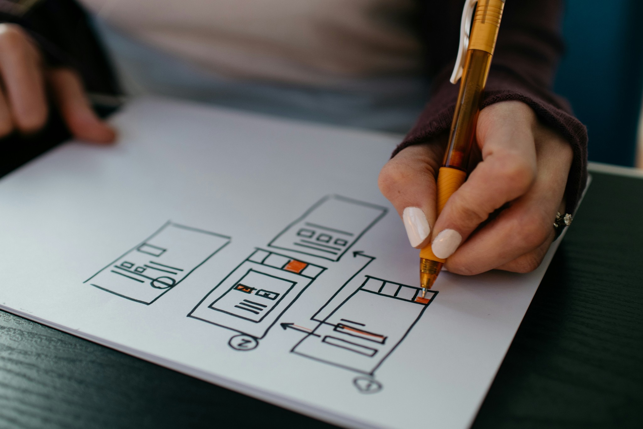 Hand drawing website wireframe design layout on white paper sheet.