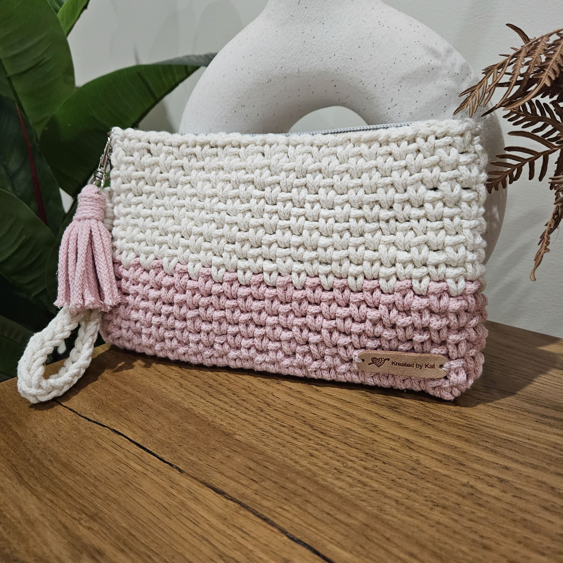 A white and pink crochet clutch