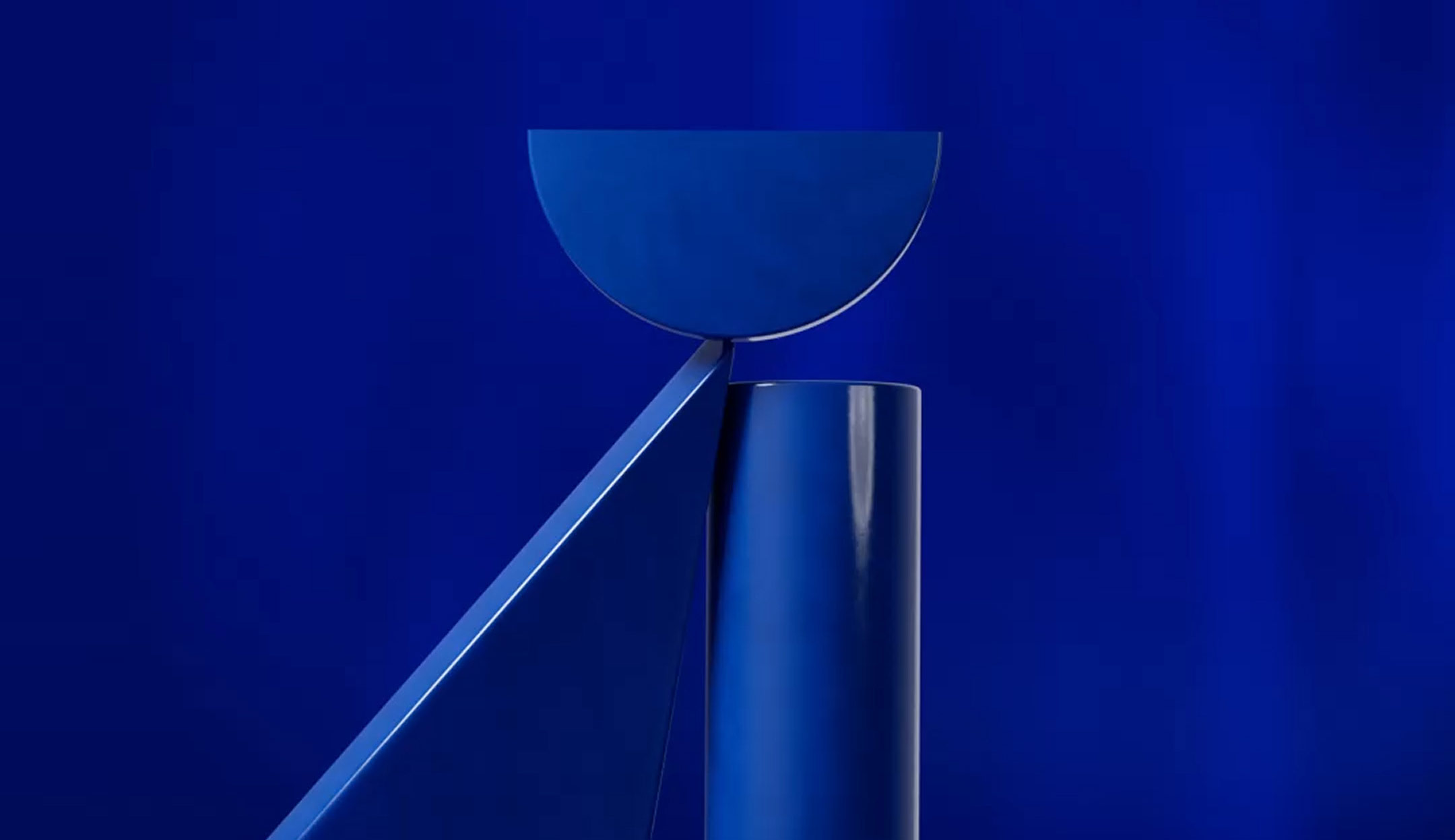 Abstract composition of blue geometric shapes including a half-circle, a diagonal bar, and a vertical cylinder against a blue background.