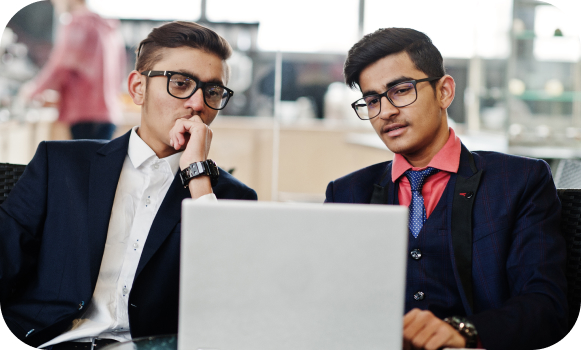 Two male working on a laptop in formals