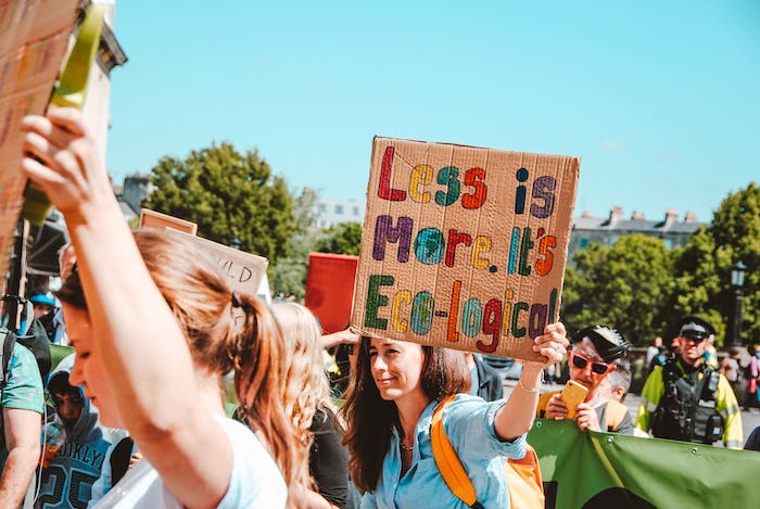 Demonstration with written on a cardboard: "Less is more. It's eco-logical".