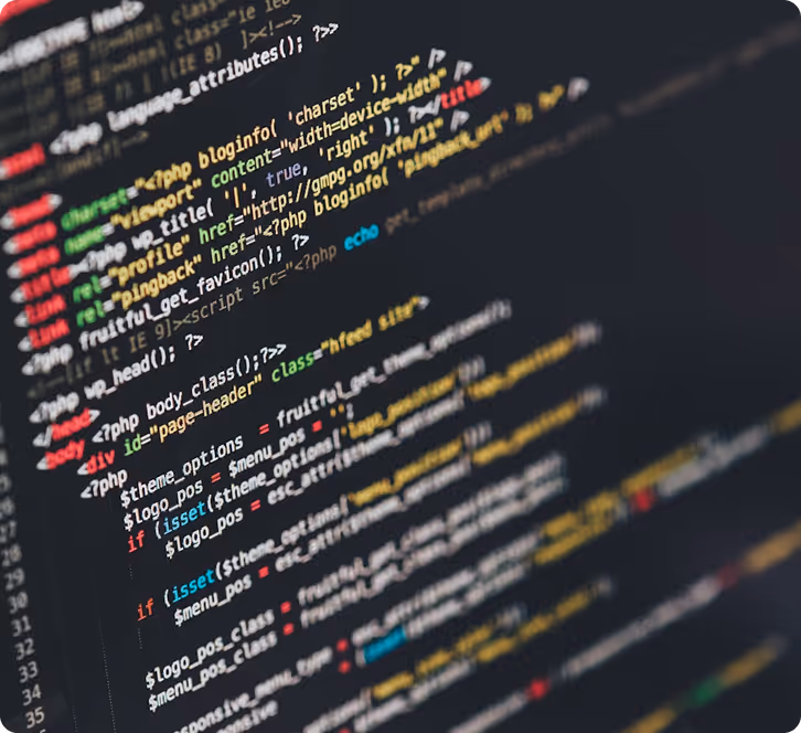 A close-up, angled view of a computer screen displaying lines of multi-colored programming code, primarily in PHP and HTML, against a dark background, typical of a code editor interface.