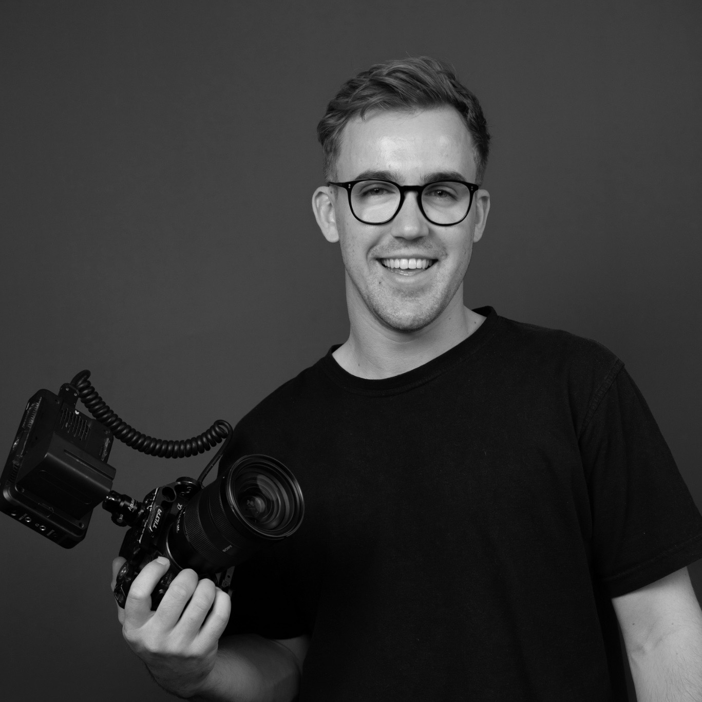 black and white image of a man holding a camera