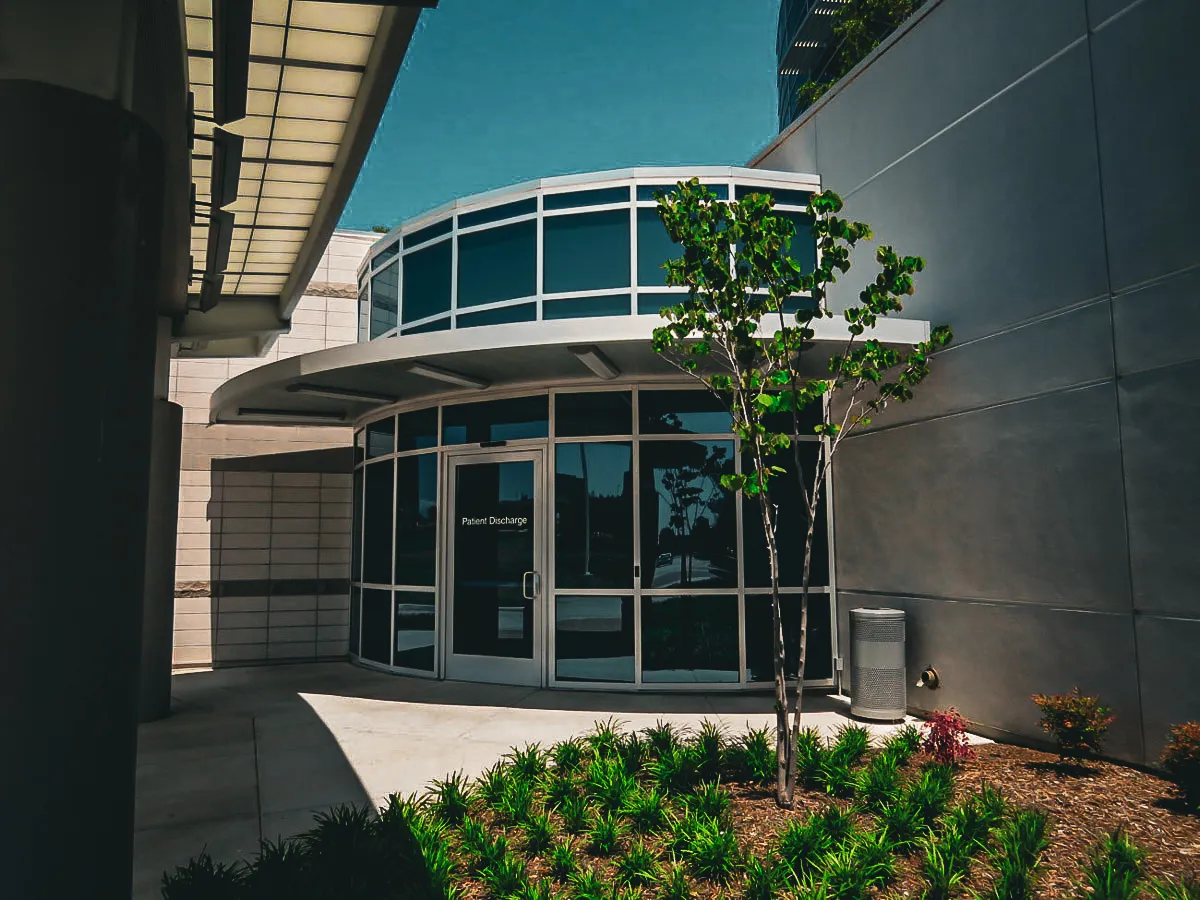 Commercial building exterior with curved windows, patient discharge signs, awnings