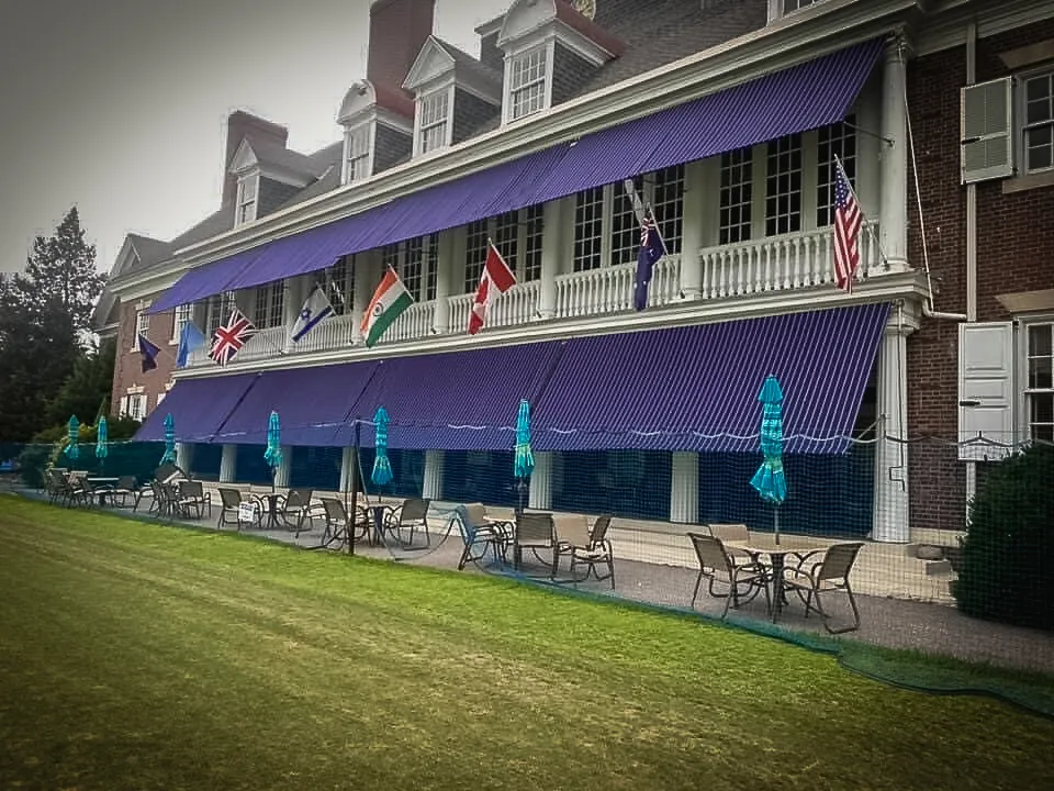 Commercial exterior with purple awnings, international flags, and outdoor seating