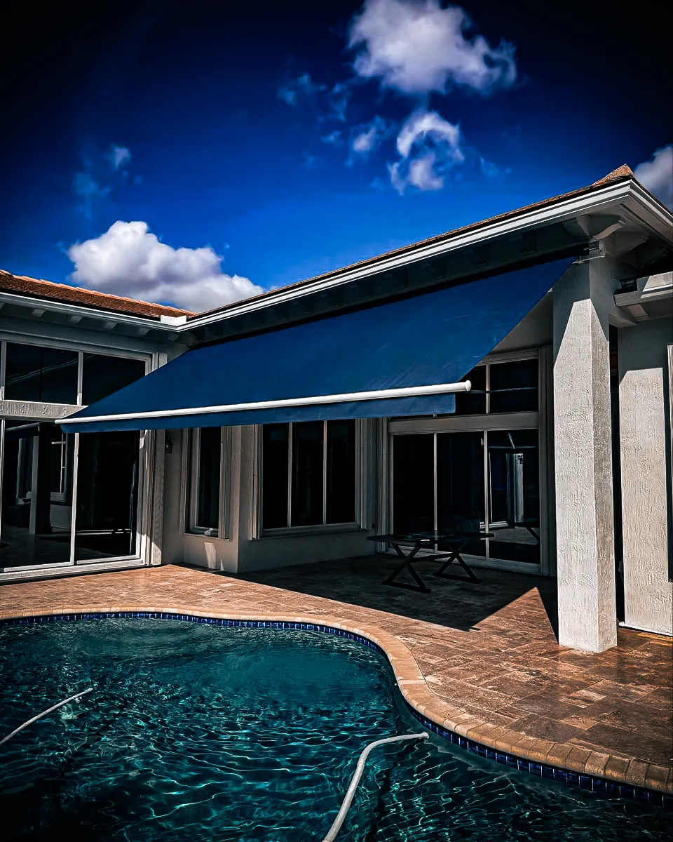 Commercial exterior with blue awnings, pool, and architectural shades