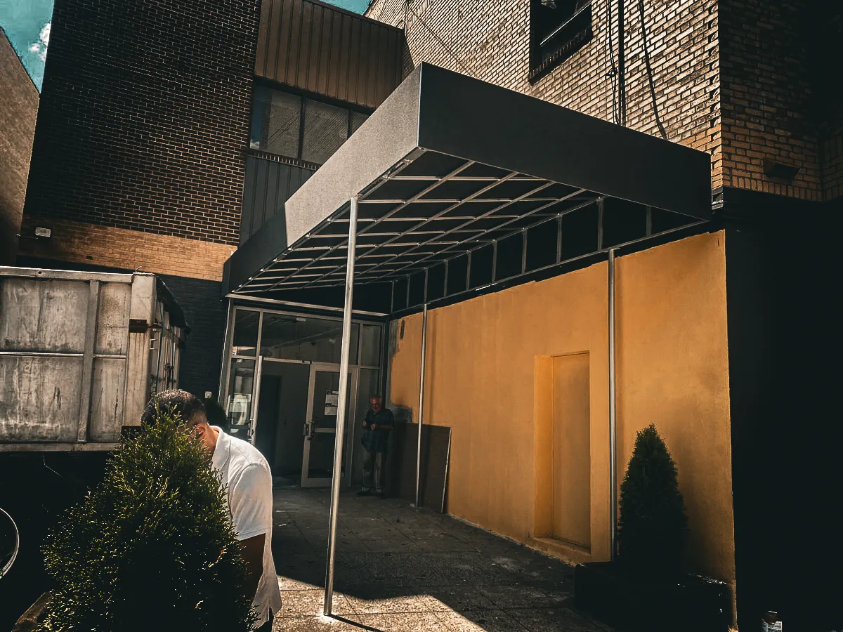 Commercial exterior with metal awnings, shades, and brick building signs