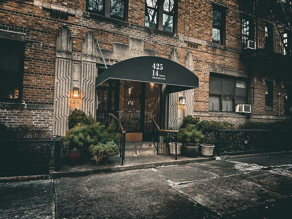 Commercial exterior with awnings, signs, and shades at Brooklyn building entrance