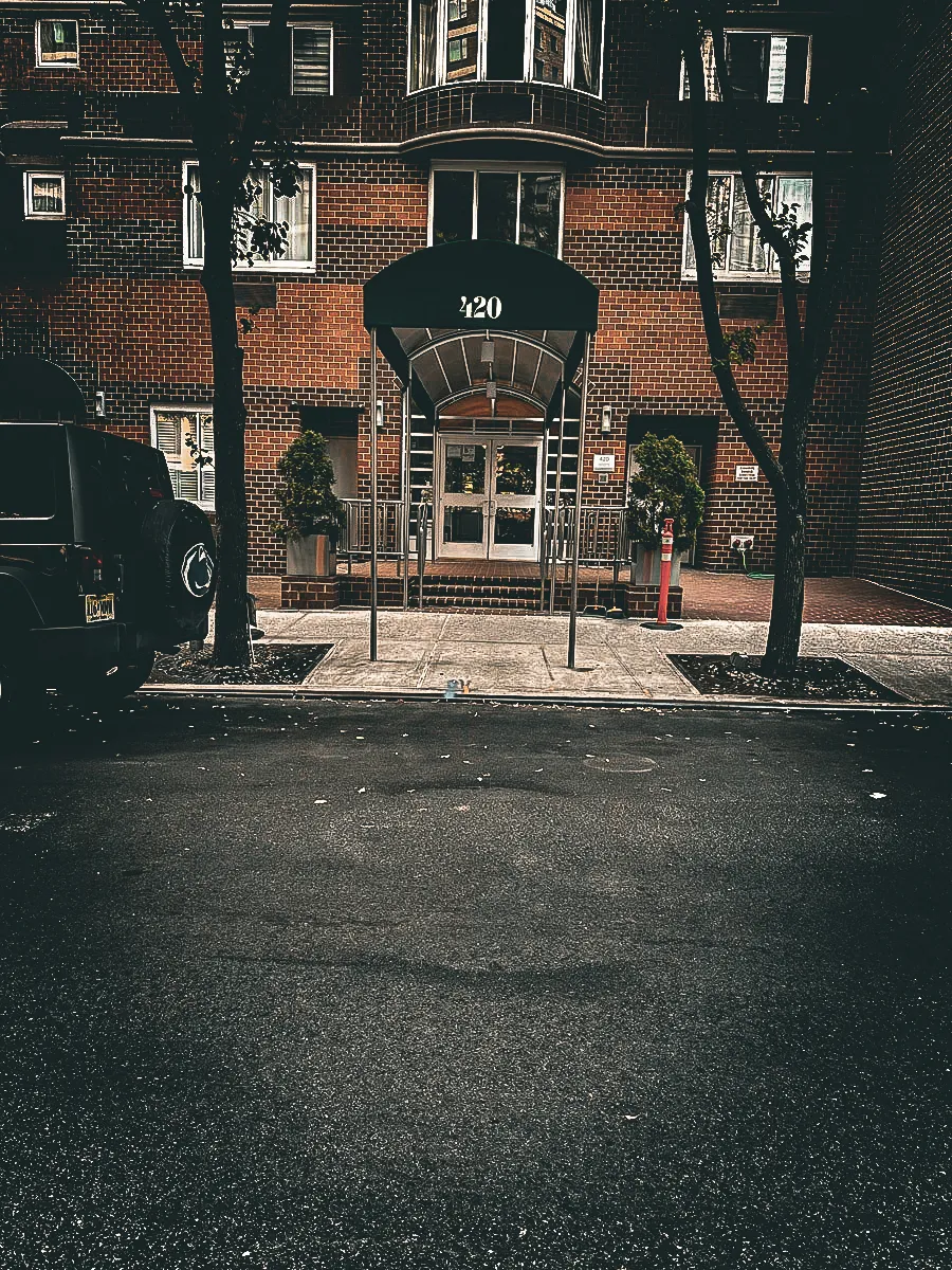 Commercial exterior with brick building, glass doors, awnings, and address sign 420