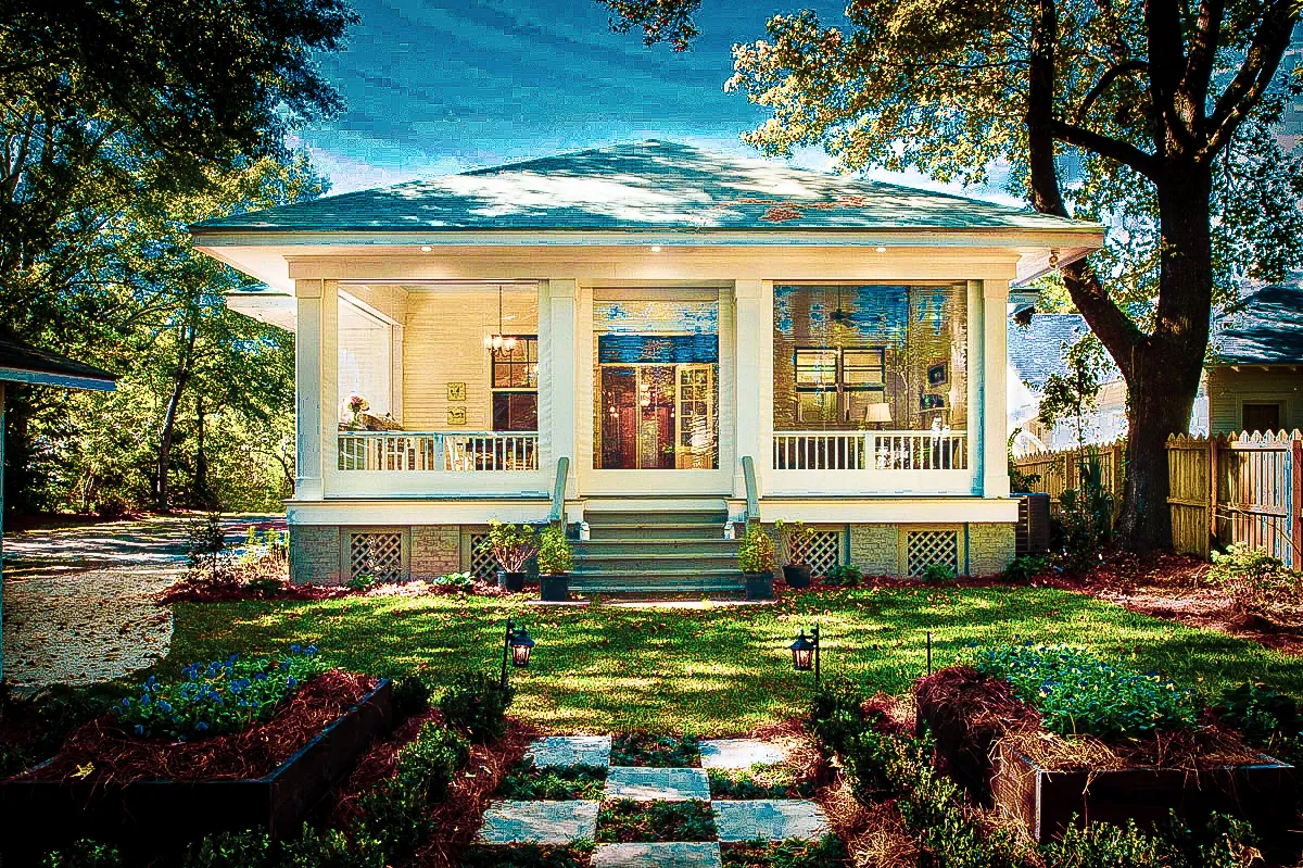Commercial exterior with white porch, shades, signs, and landscaped garden